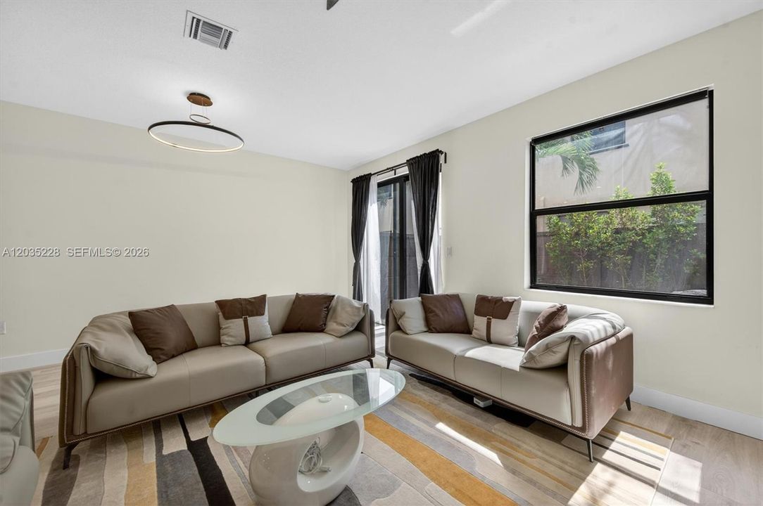 Sunlit living room with abundant natural light and modern pendant lighting for an elevated, designer feel.