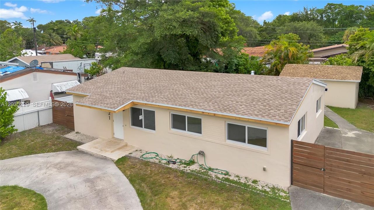 Angled aerial view featuring the new roof, updated exterior, and privacy fencing.