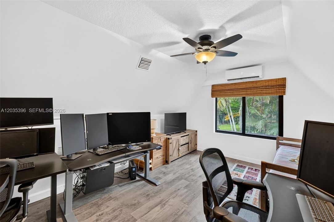 Upstairs Bedroom, currently being used as an office / guest room, with Mini Split HVAC and view to pool area