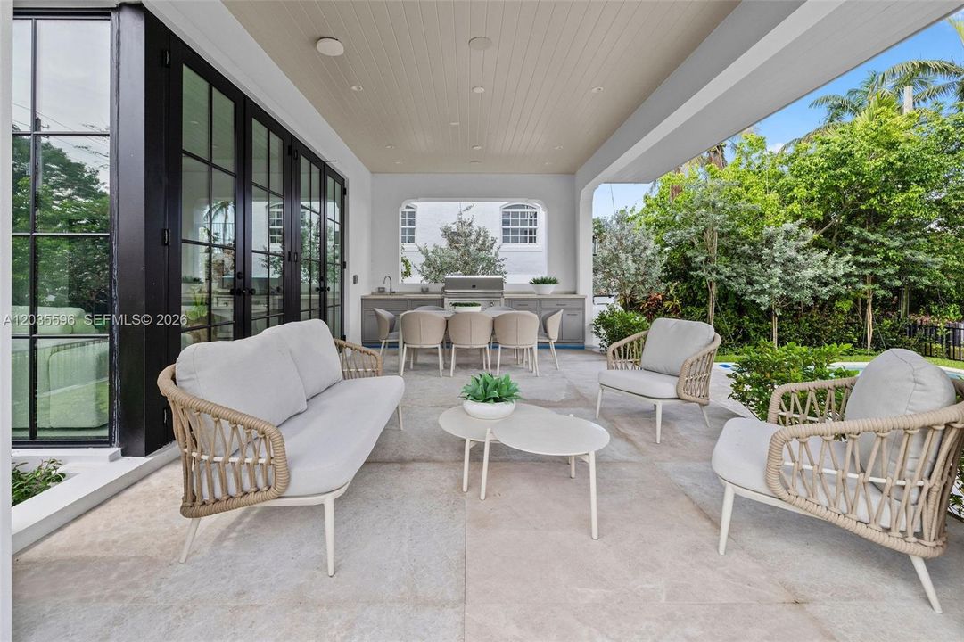 Outside living room with kitchen overlooks pool