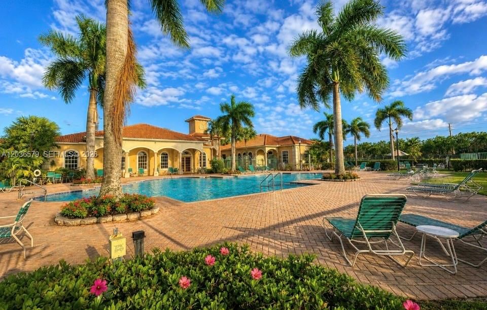 Bright resort-style community pool with tropical surroundings, relaxing lounge areas & clubhouse amenities offering the perfect South Florida lifestyle in desirable Boynton Beach.