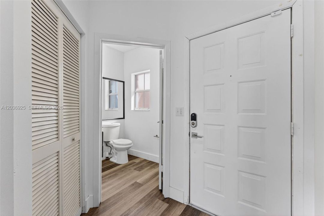 Guest bathroom is located next to the front door.