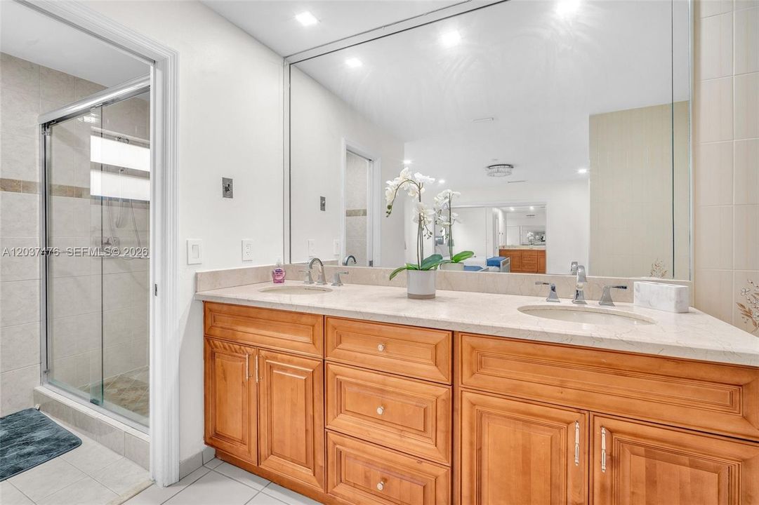 Master bathroom with dual sinks, shower, and bathtub.