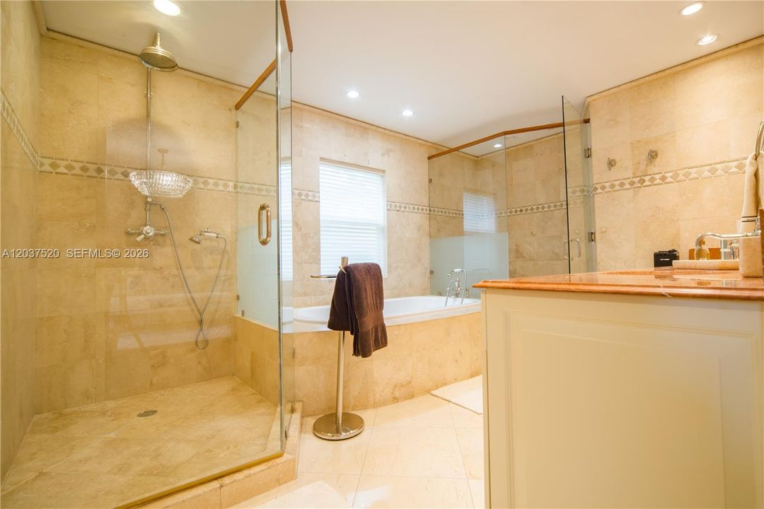 Primary suite Bathroom with dual sinks, glass shower enclosure, water closet and soaking tub.