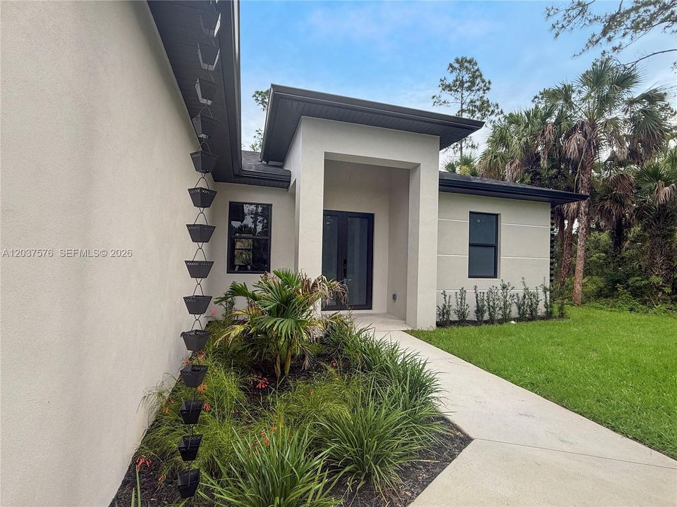 Contemporary exterior architecture with a recessed entry, featuring smooth stucco finishes and a dark soffit