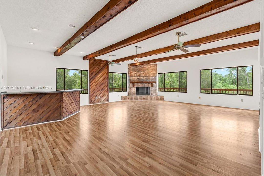 Inviting living space featuring a fireplace framed by a warm wood accent wall and a built-in bar area, creating an ideal setting for relaxing and entertaining.