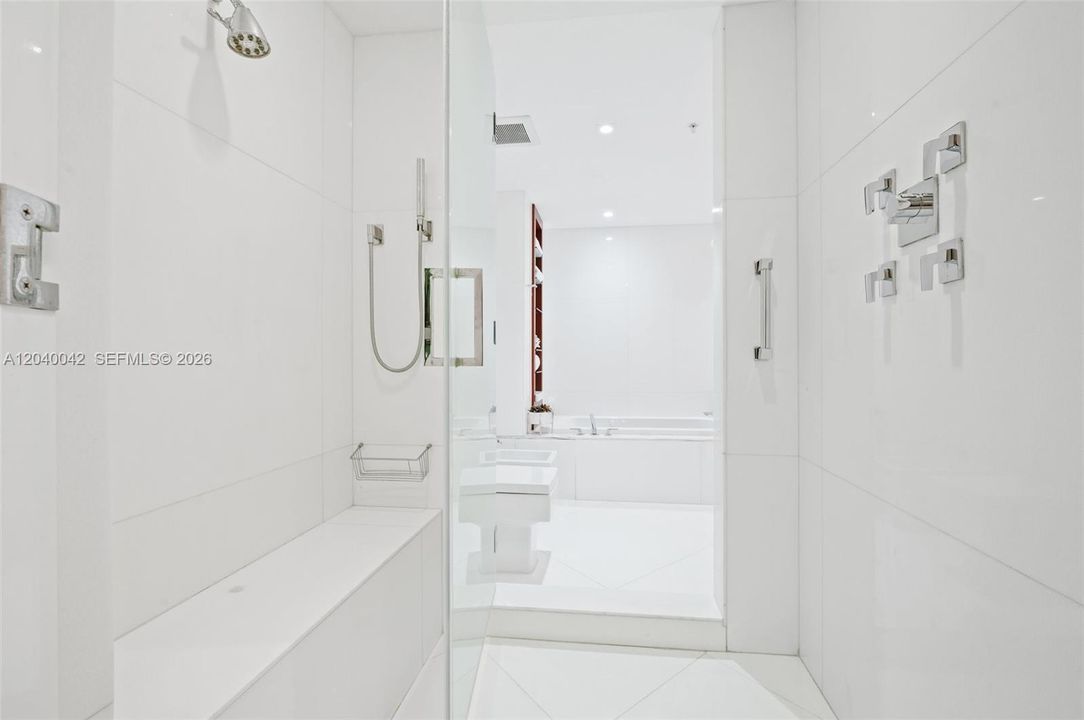 Glass-enclosed shower with premium fixtures.