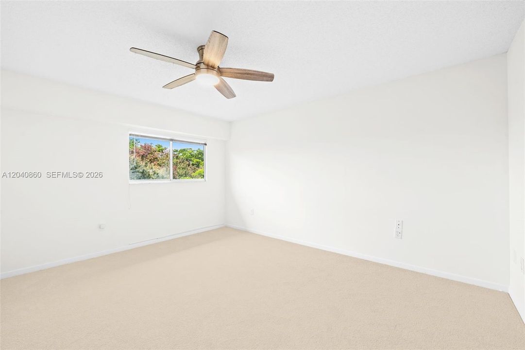 Primary bedroom with en suite bath & walk in closet with custom cabinerty.