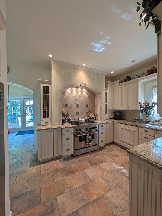 Notice the tile flooring, the recessed lights, the Thermador Professional Gas Range!!  The arched hallway to the left leads you to the Familyroom and the French Doors at the end of the Familyroom leads you out to the patio!!
