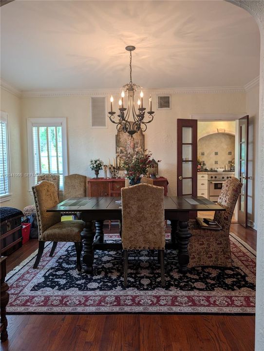 This a wonderful sized diningroom with a bank of windows to the left and one can see beyond the French Doors into the Kitchen. Just like the Livingroom, notice the wood floors.
