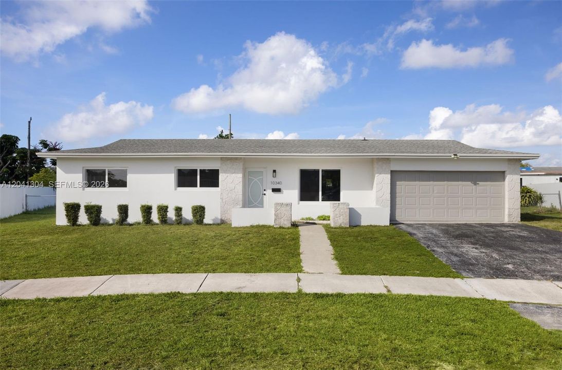 Front Elevation – Contemporary curb appeal highlighted by a crisp neutral color palette, manicured landscaping, and a covered entryway. The wide frontage enhances the home's attractive street presence.