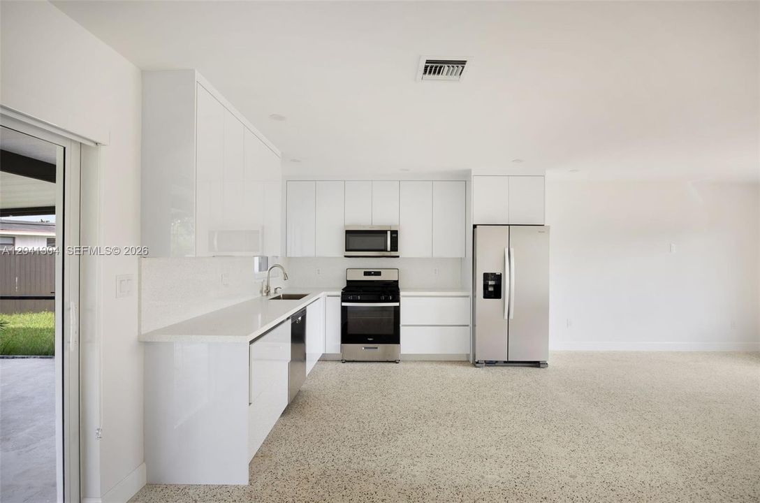 Kitchen – Modern kitchen featuring sleek cabinetry, solid-surface countertops, and stainless steel appliances. Designed for both functionality and style, with ample workspace and storage.