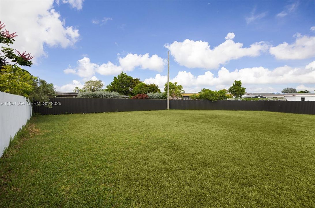 Backyard – Oversized grassy backyard showcasing exceptional outdoor space and a bright, open atmosphere. Perfect for enjoying outdoor activities and entertaining guests.