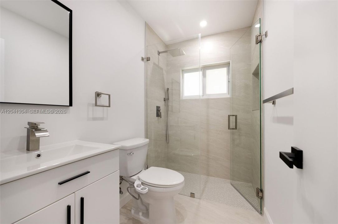 Bathroom – Beautifully updated bathroom showcasing a frameless glass walk-in shower, contemporary fixtures, and elegant tile finishes. A sleek, spa-inspired design with a clean, modern feel.