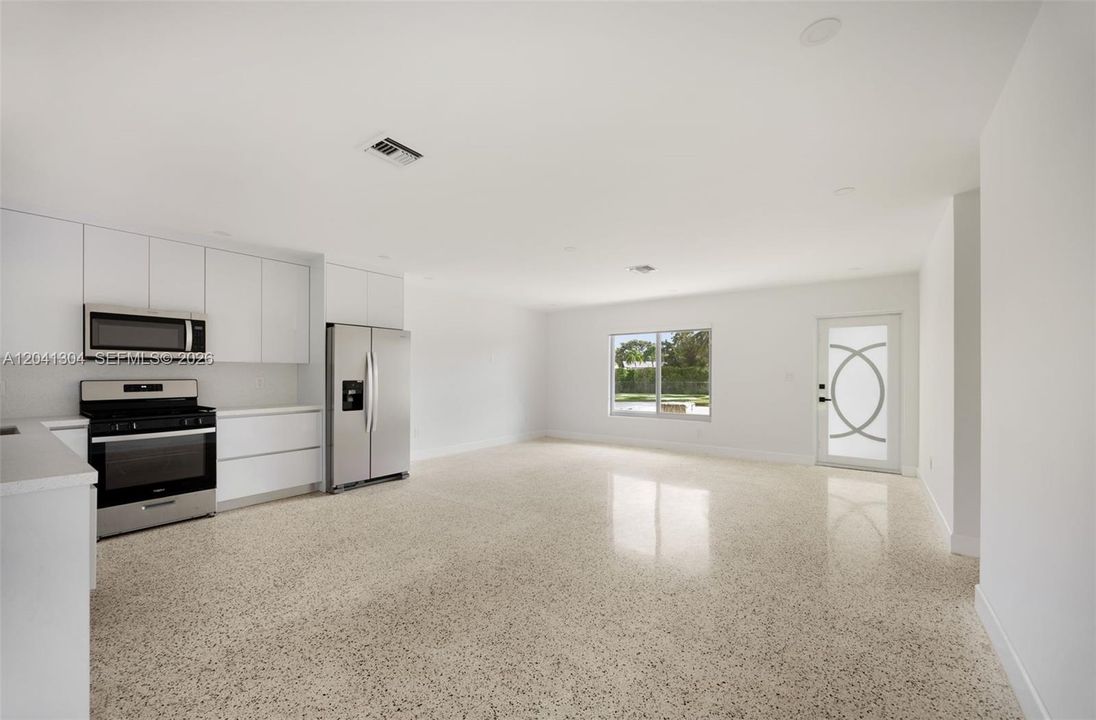 Living Room & Kitchen – Bright open-concept living space with abundant natural light, recessed lighting, and seamless flow into the kitchen. A versatile layout offers plenty of room for everyday living and entertaining.