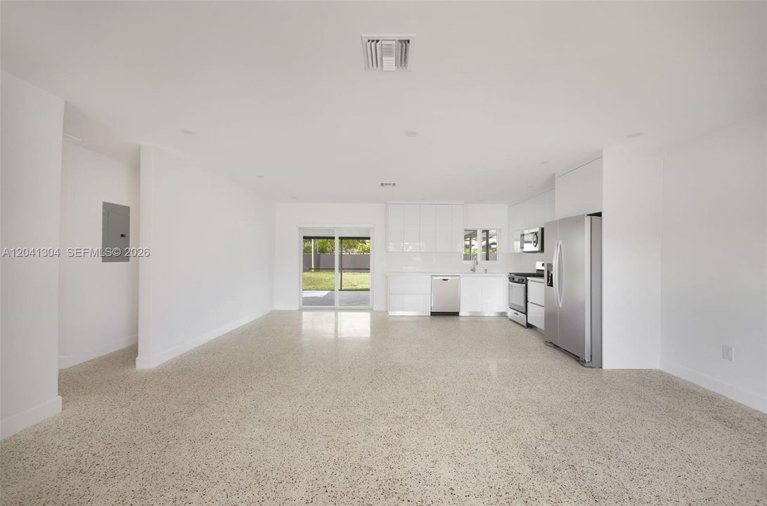 Open Living Area – Spacious main living area showcasing an airy design and easy access to the backyard through sliding glass doors. The open layout provides flexibility for multiple furniture arrangements.