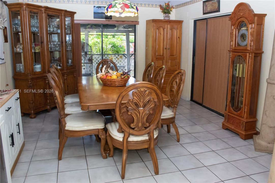 What would traditionally be the family room, is currently being used as a dining room and to the right through those dark sliding doors there is an enclosed Florida Room which is very spacious and it has a door that leads to the backyard as well as closet and a another door that leads to the hallway bath that is shared by the 3 bedrooms in the hallway that leads from the Living Room.