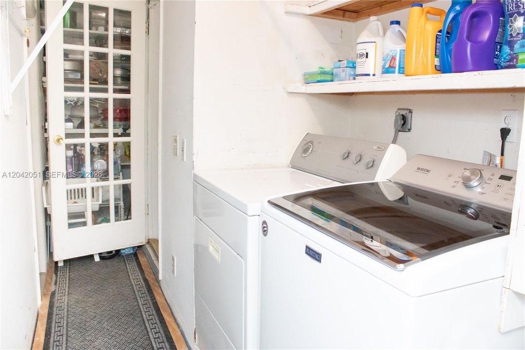 The open door on the right leads to the kitchen. The closed door on the left, leads to the Studio.