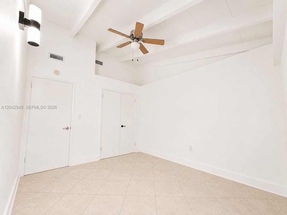 Bright bedroom featuring vaulted ceilings, a ceiling fan, and abundant natural light.