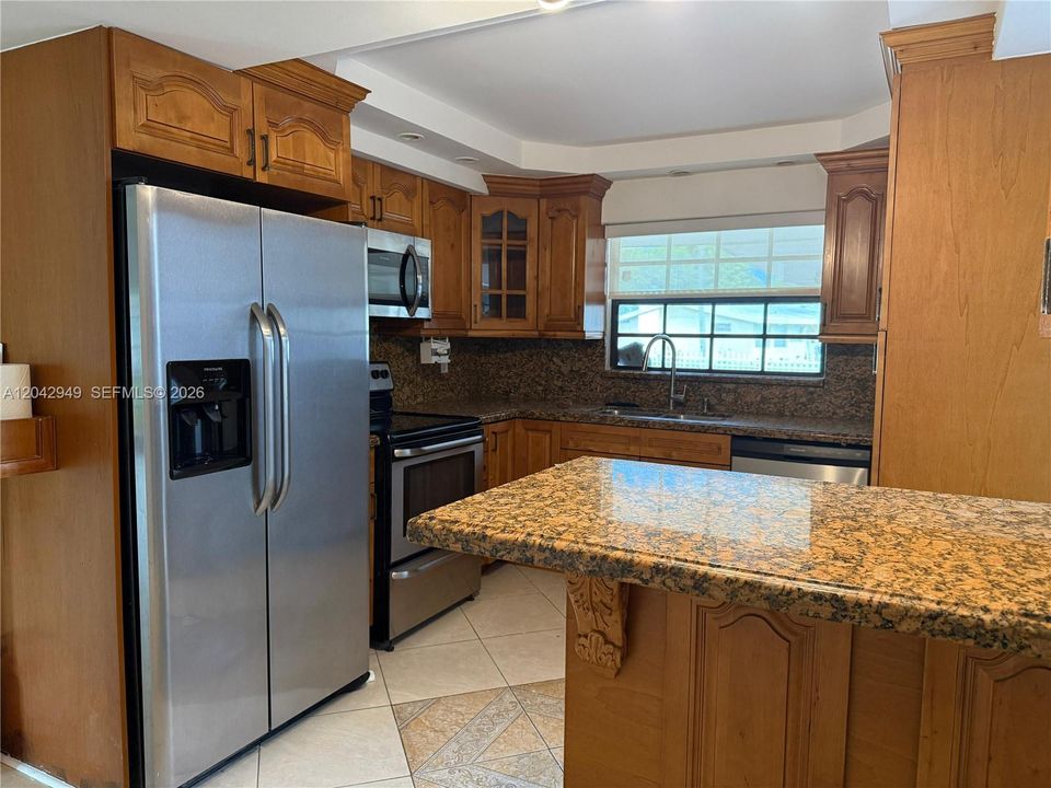 Beautiful kitchen featuring granite countertops, stainless steel appliances, including a dishwasher, abundant cabinetry, and a functional layout perfect for everyday living.