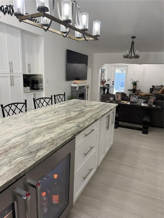 The 15 feet island with under the counter refrigerator and wine cooler.  Cabinets are all pull-out drawers.  Pantry and coffee station in background.