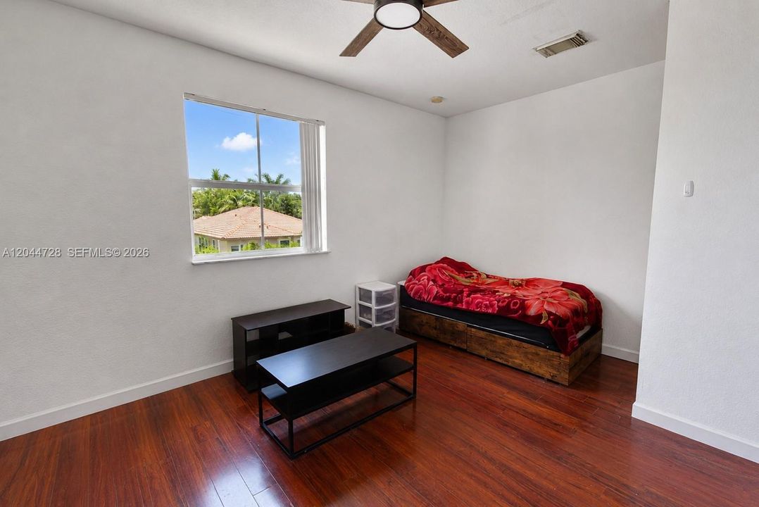 1st Master Bedroom with laminated flooring, simple layout, walking closet, and direct access to a bright vanity area. Functional space with neutral finishes.