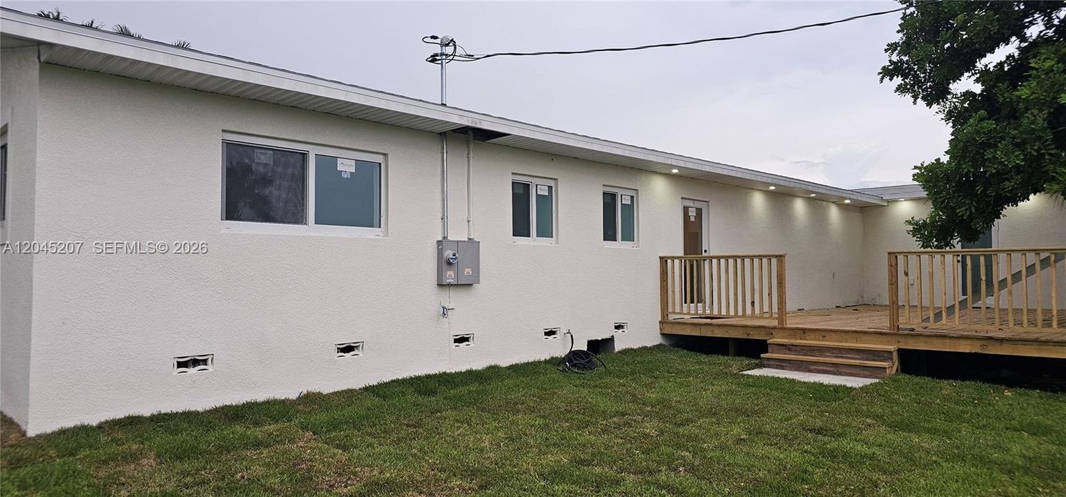 spacious yard with illuminated rear deck