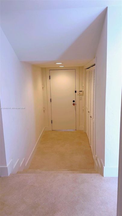 Hallway leading to garage with closets on side