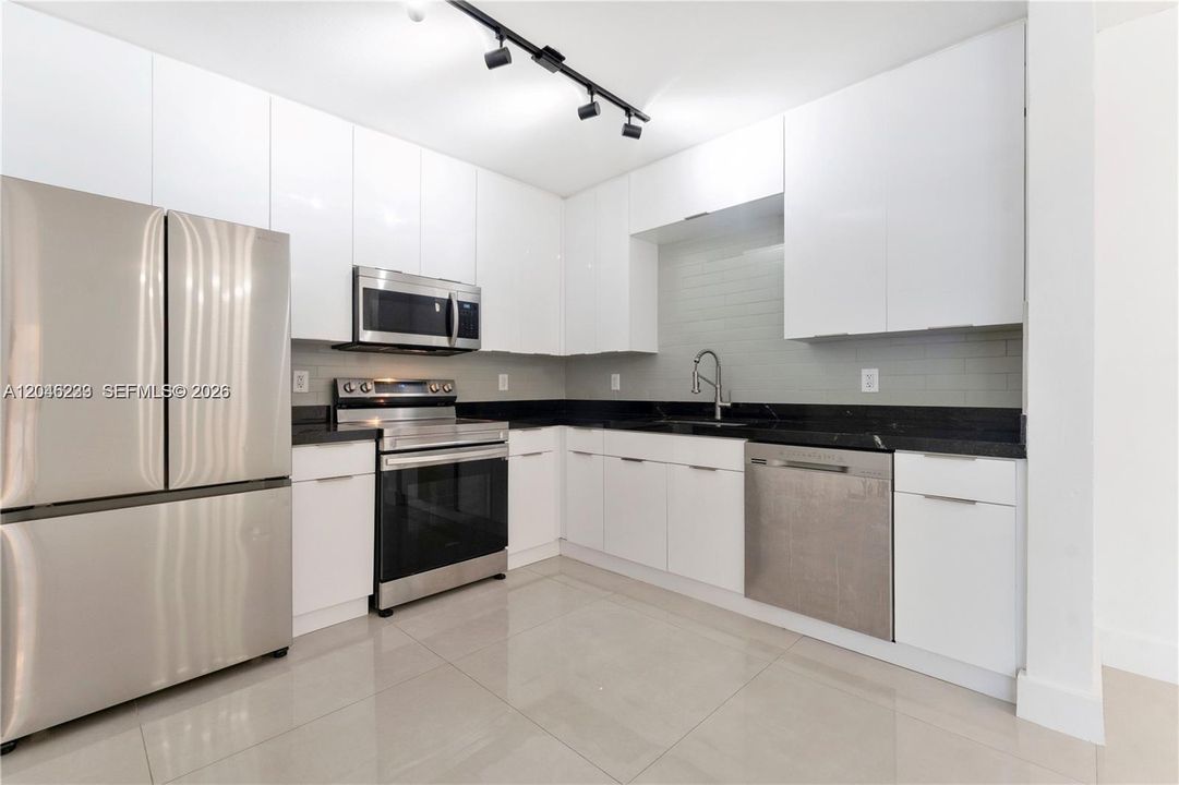 Modern kitchen with quartz countertops and stainless steel appliances.