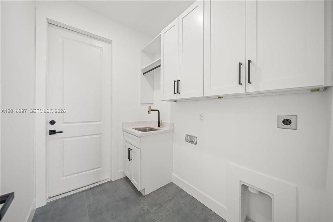 aundry room featuring custom upper cabinetry for added storage