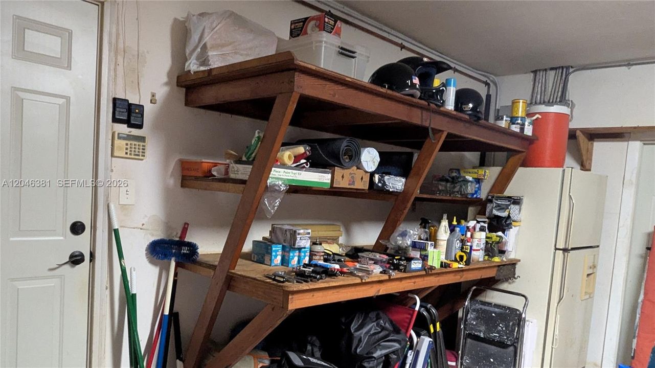 Garage entry to house, shelves, refrigerator, exit door