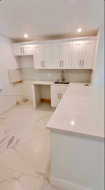 Stocked with stainless steel appliances including a French door refrigerator.
