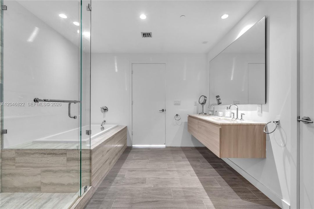 Primary bath with dual vanities, soaking tub, and walk-in shower