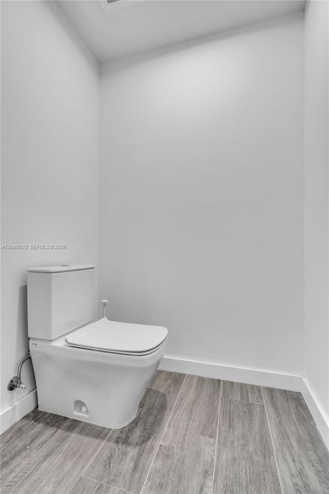 Private water closet with wood-look tile flooring