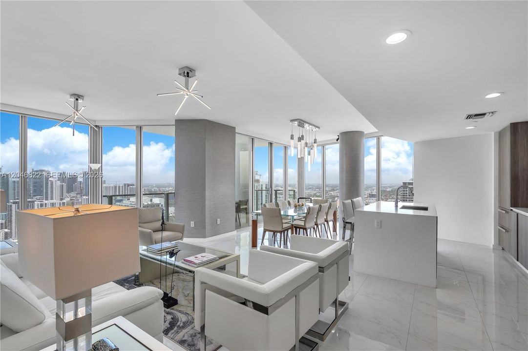 Open living and kitchen great room framed by floor-to-ceiling glass