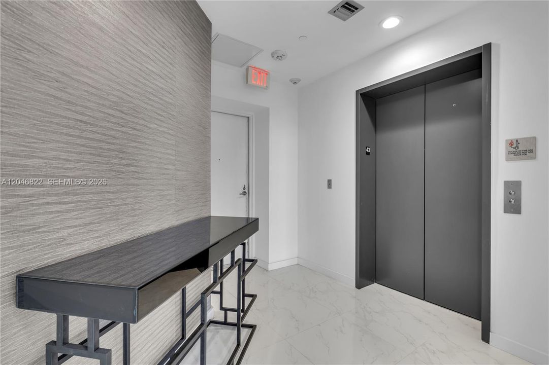 Private elevator landing and entry foyer with marble flooring