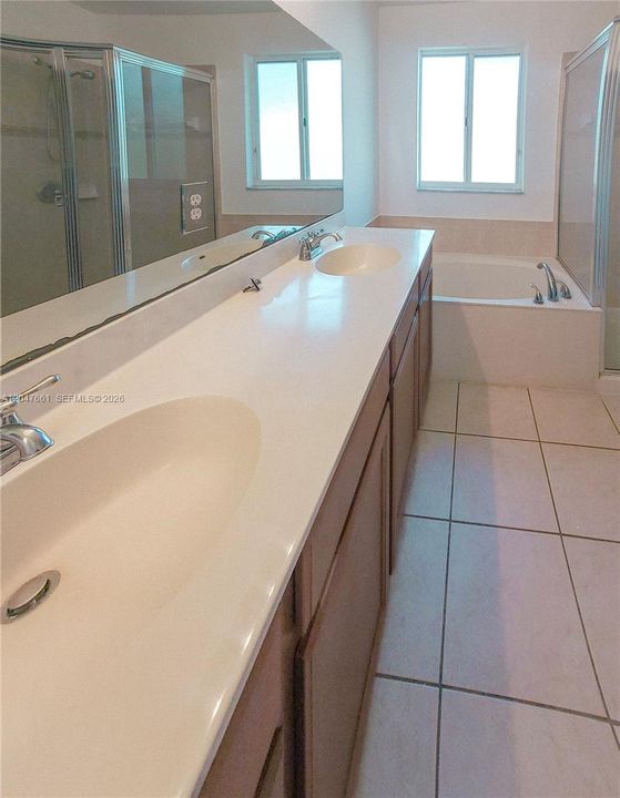 Spacious primary ensuite bathroom with single vanity, tub/shower combination, and private water closet.