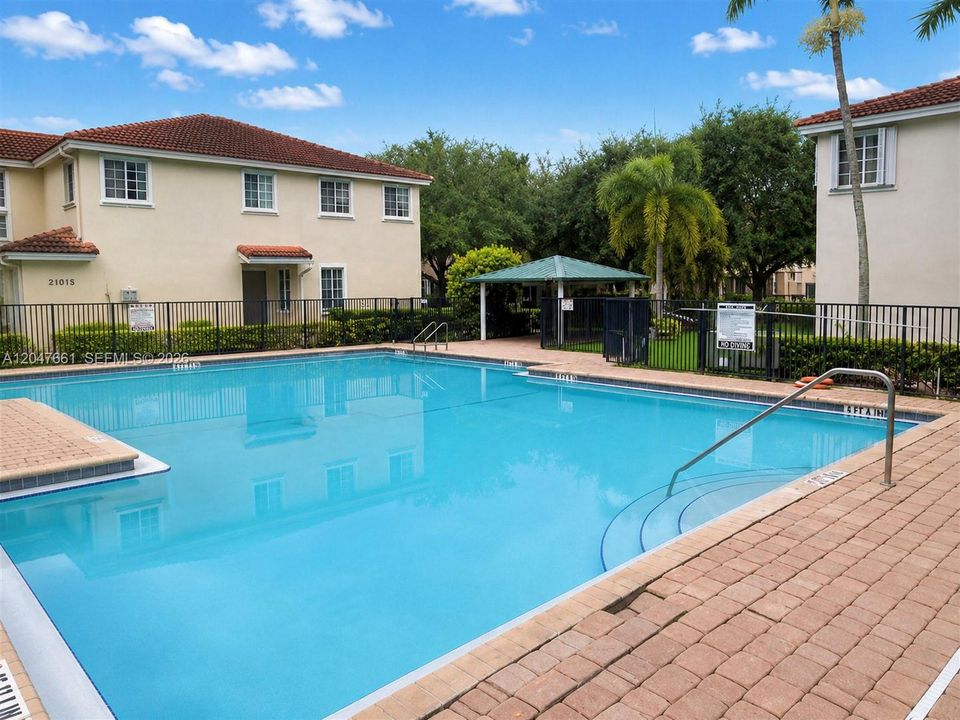 Community swimming pool with spacious sun deck for residents to enjoy.