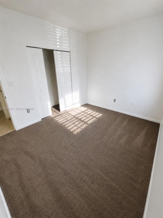 Alternate view of the first-floor bedroom showcasing the spacious layout and closet.