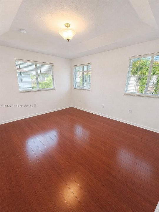 Spacious Primary Bedroom featuring wood-look flooring and abundant natural light.