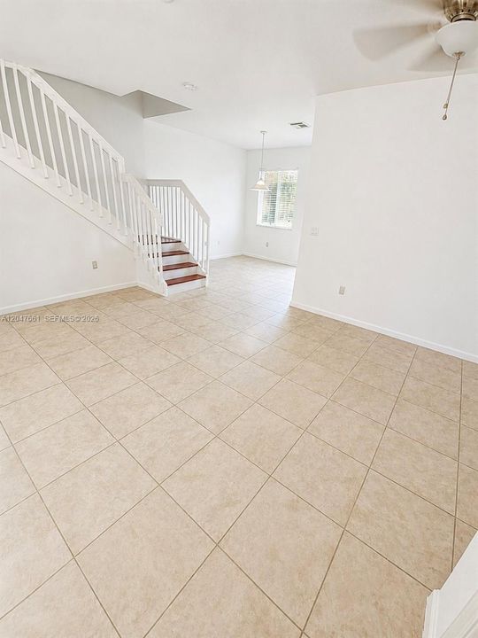 Spacious Living Room with abundant natural light, and an open layout connecting to the entry and staircase.