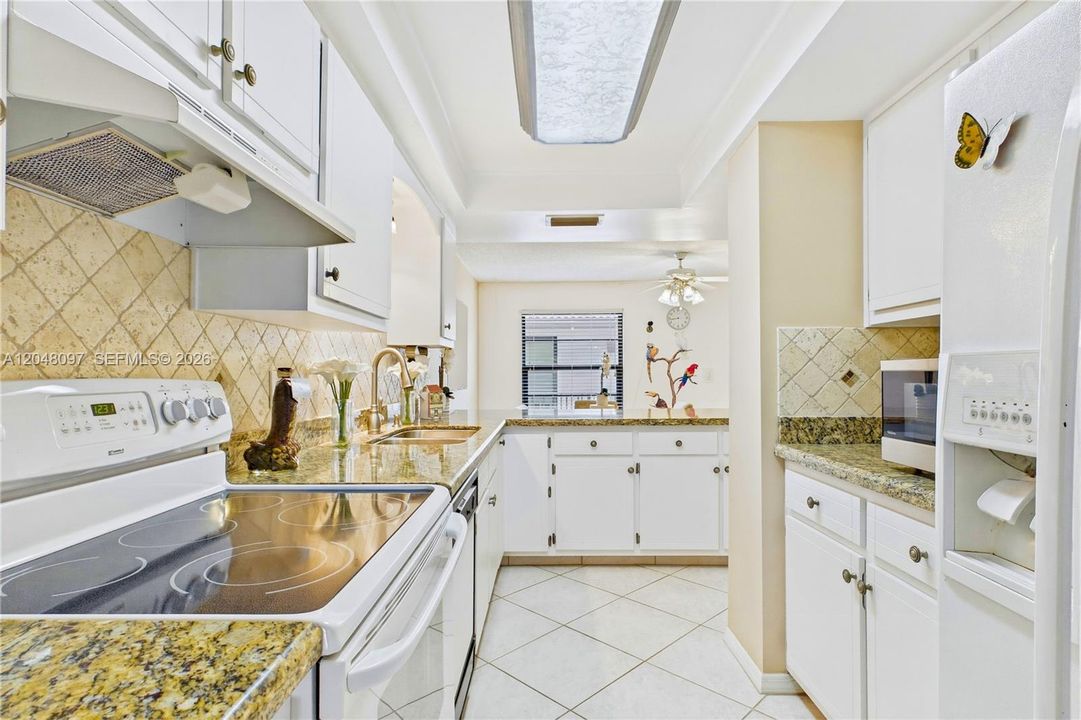 Bright galley kitchen with abundant cabinet and counter space