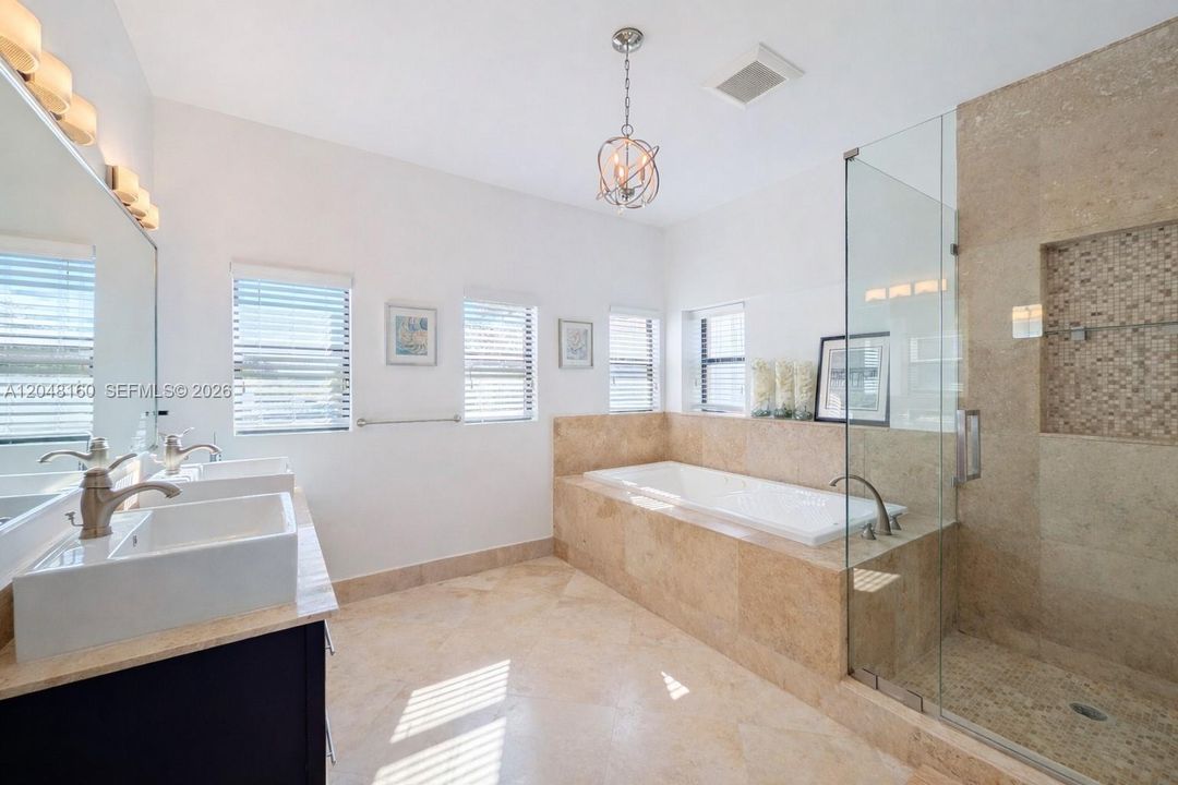 Primary suite bathroom with a whirlpool bath, glass shower, his and her sinks, a Toto bidet and separate conventional toilet.