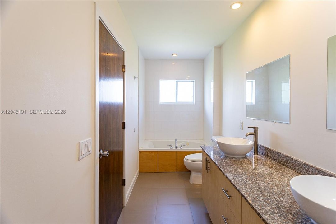 Master bathroom with jacuzzi, shower and dual sinks