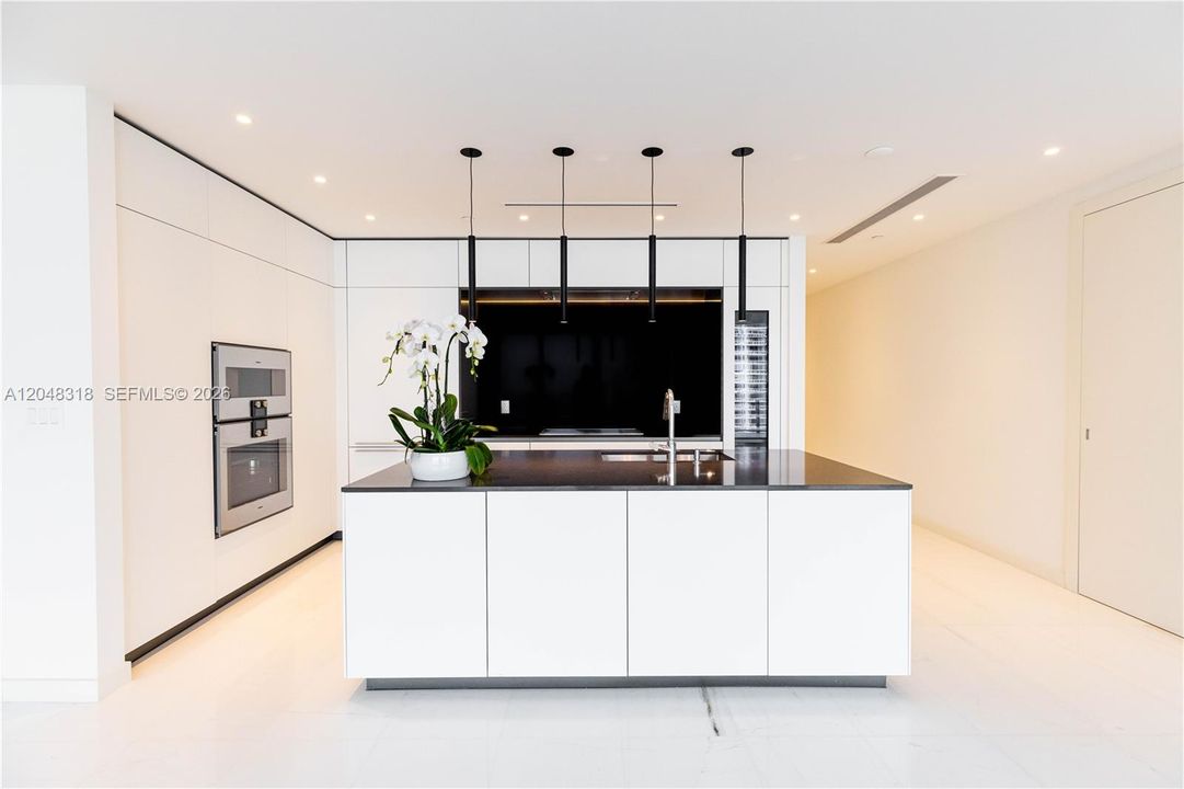 an open chef’s kitchen with custom Bulthaup cabinetry and top-of-the-line Gaggenau appliances is complemented by solid-core Bertolotto doors and imported Thassos.