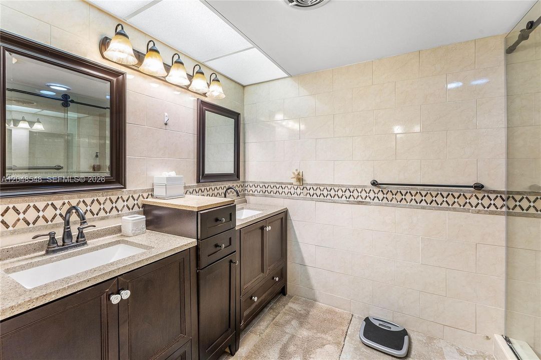 Updated primary bath with dual sinks, glass enclosed shower