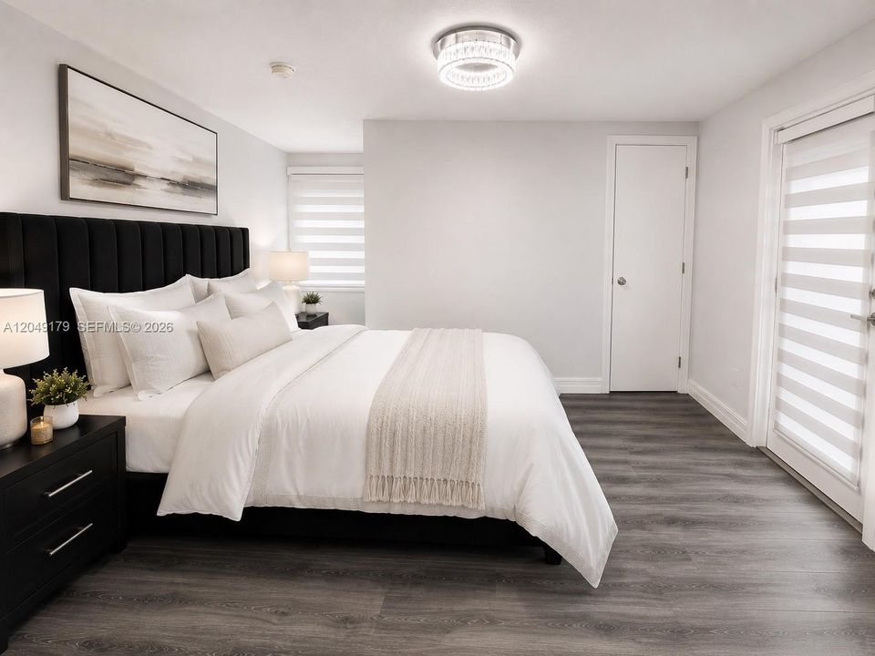 Private en-suite bathroom featuring marble flooring, floor-to-ceiling travertine stone, and a spacious walk-in shower with timeless natural finishes.