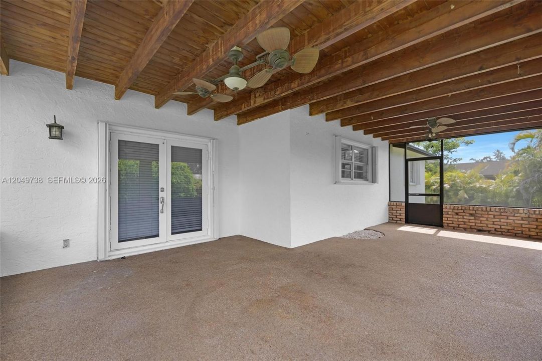 The large screened-in patio built of Chicago brick with 2 side doors access to the yard