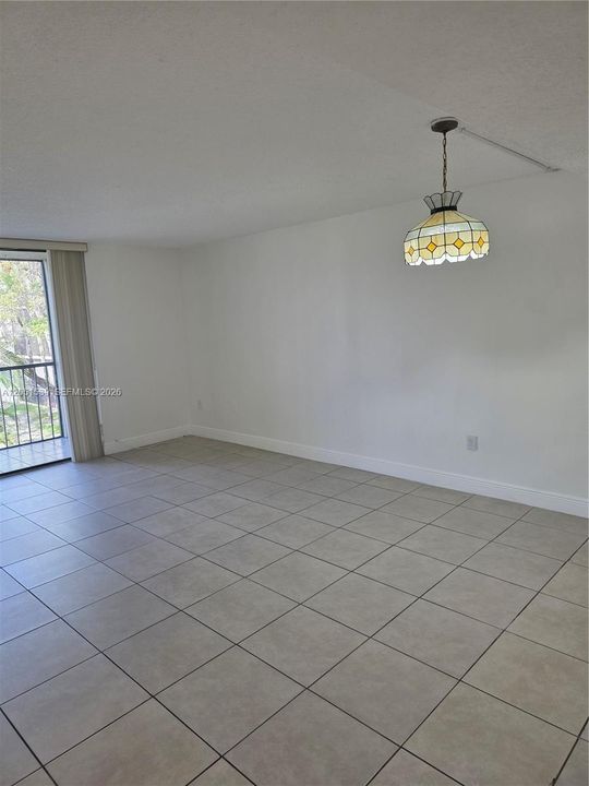 TILED LIVING ROOM WITH ACCESS TO SCREENED BALCONY