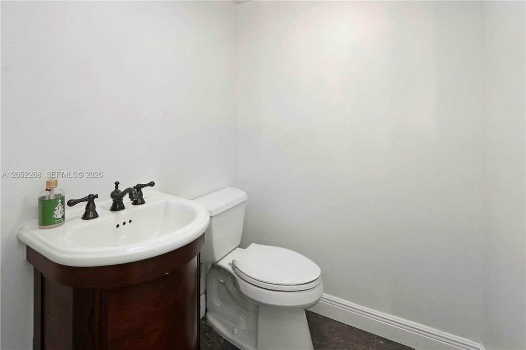 Medio baño en planta baja con diseño funcional, acabado impecable y un moderno tocador con pedestal, diseñado para ofrecer comodidad y practicidad a los residentes e invitados.